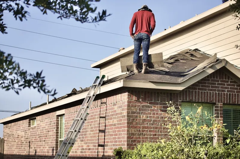 Professional roofer working on a residential roof in North Fair Haven